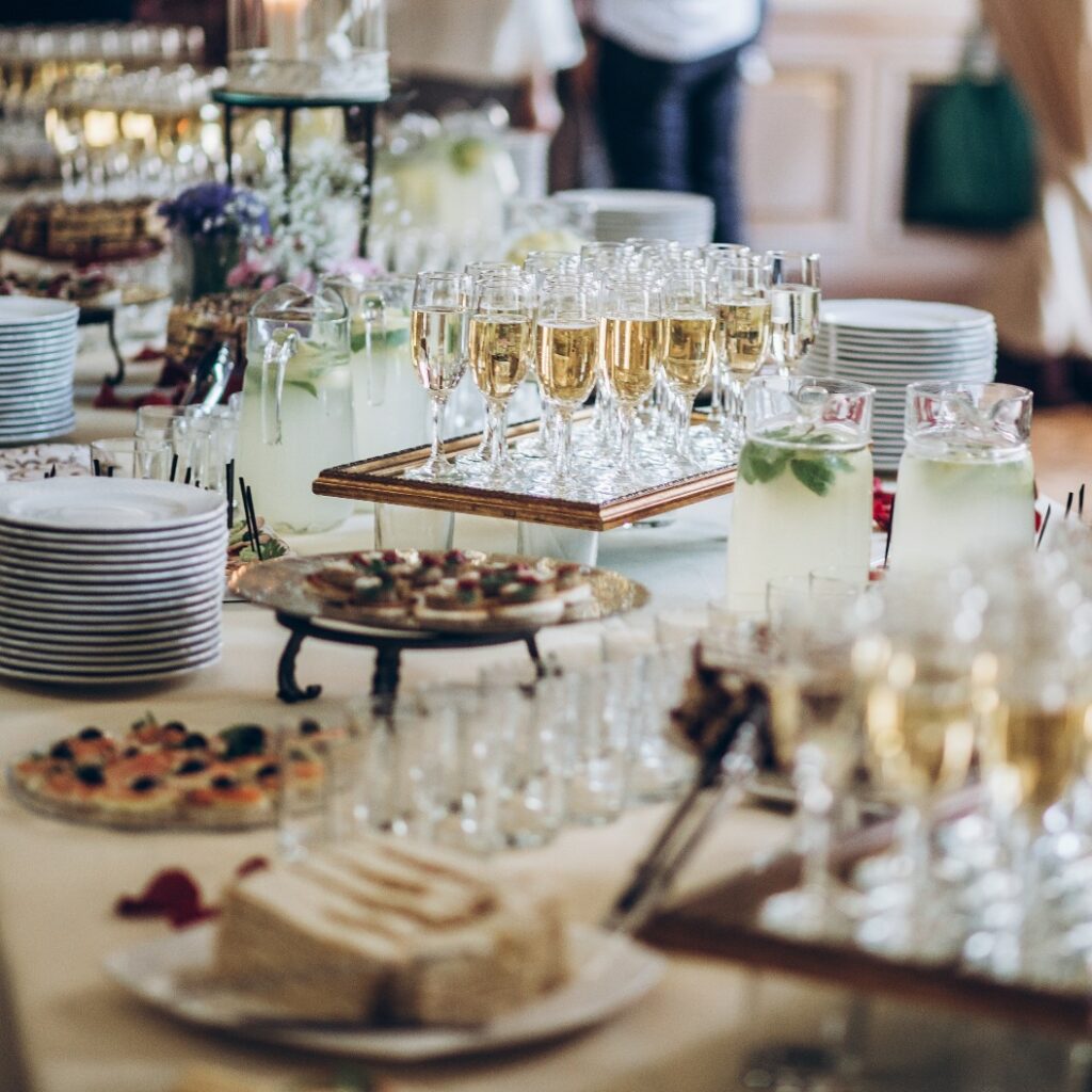 stylish champagne glasses and food  appetizers on table at wedding reception. luxury catering at celebrations. serving food and drinks at events concept